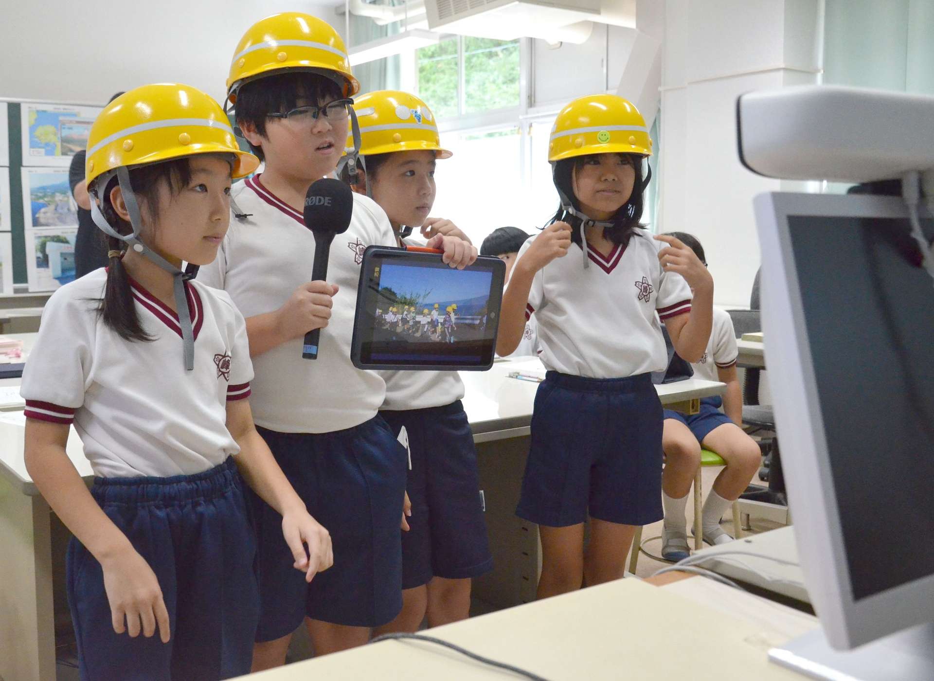 ヘルメットをかぶって登校している様子を紹介する児童たち＝鹿児島市の桜峰小学校