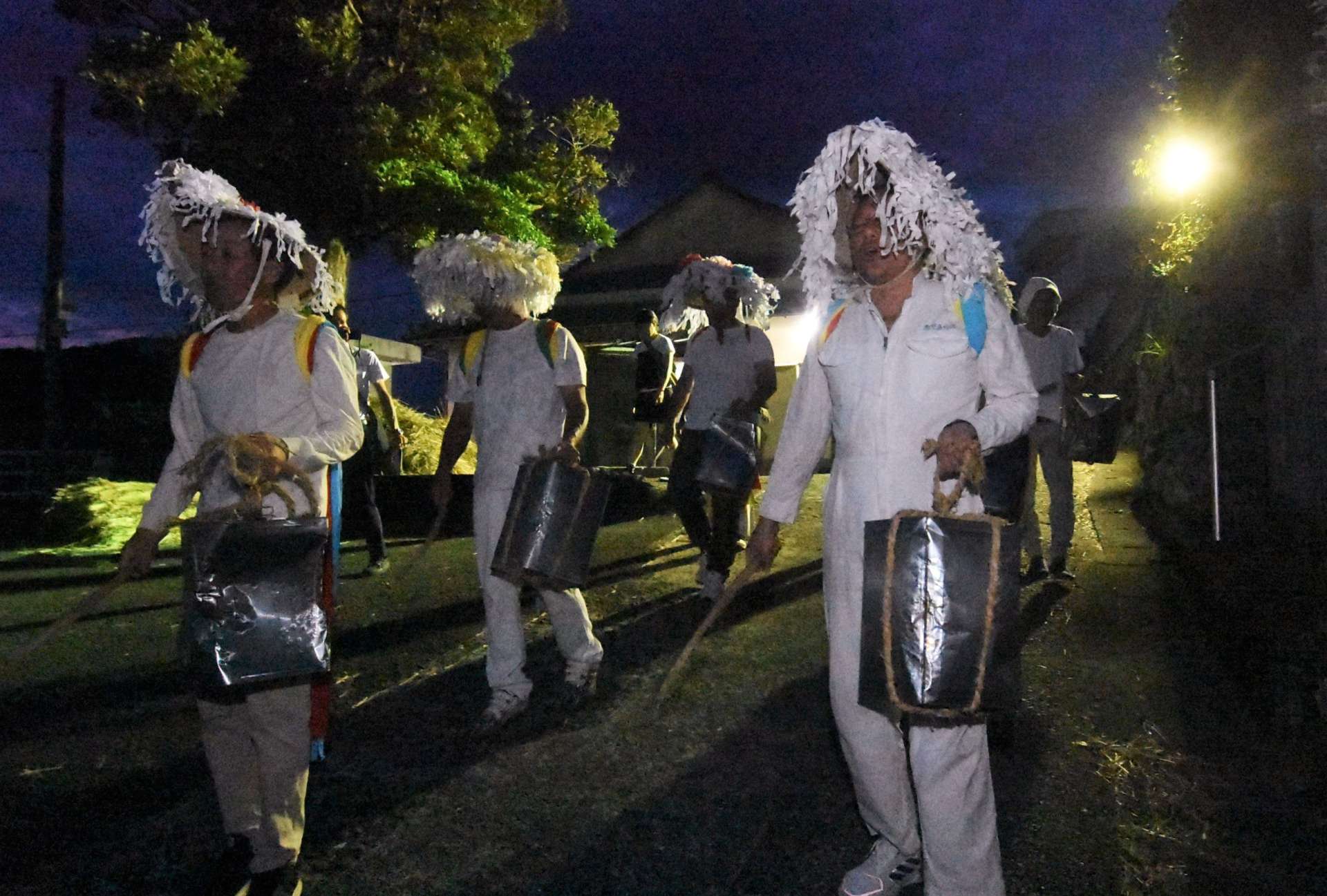 一斗缶をたたき筋回りする男衆＝南さつま市坊津の鳥越集落