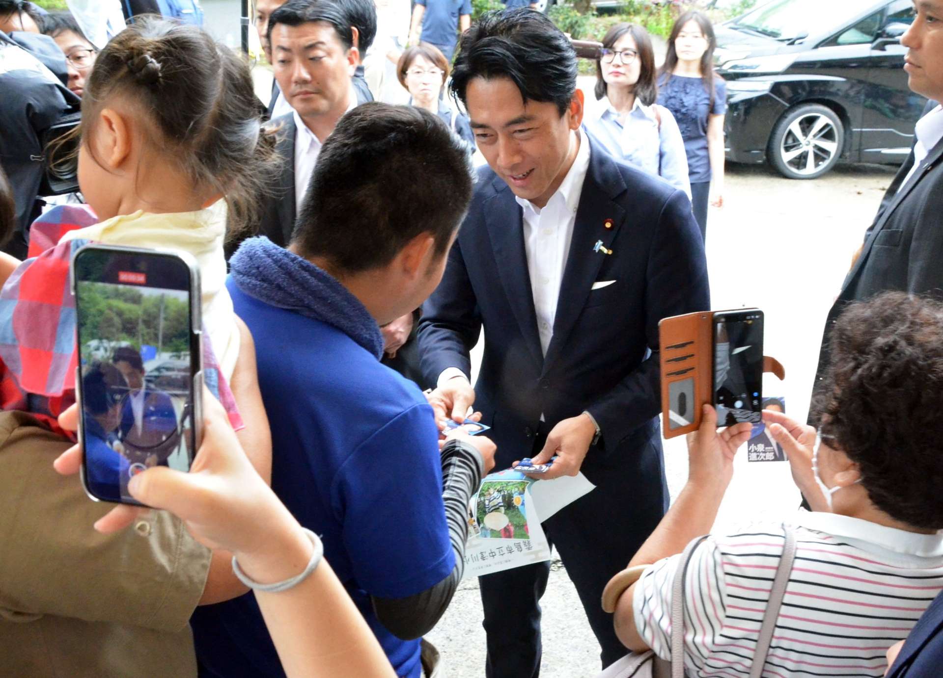 視察先に駆け付けた住民らと交流する小泉進次郎氏＝２３日午前、霧島市牧園町下中津川