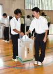 実際の公職選挙で使われる投票箱と記載台で生徒会長選挙の投票をする生徒＝伊佐市の大口高校
