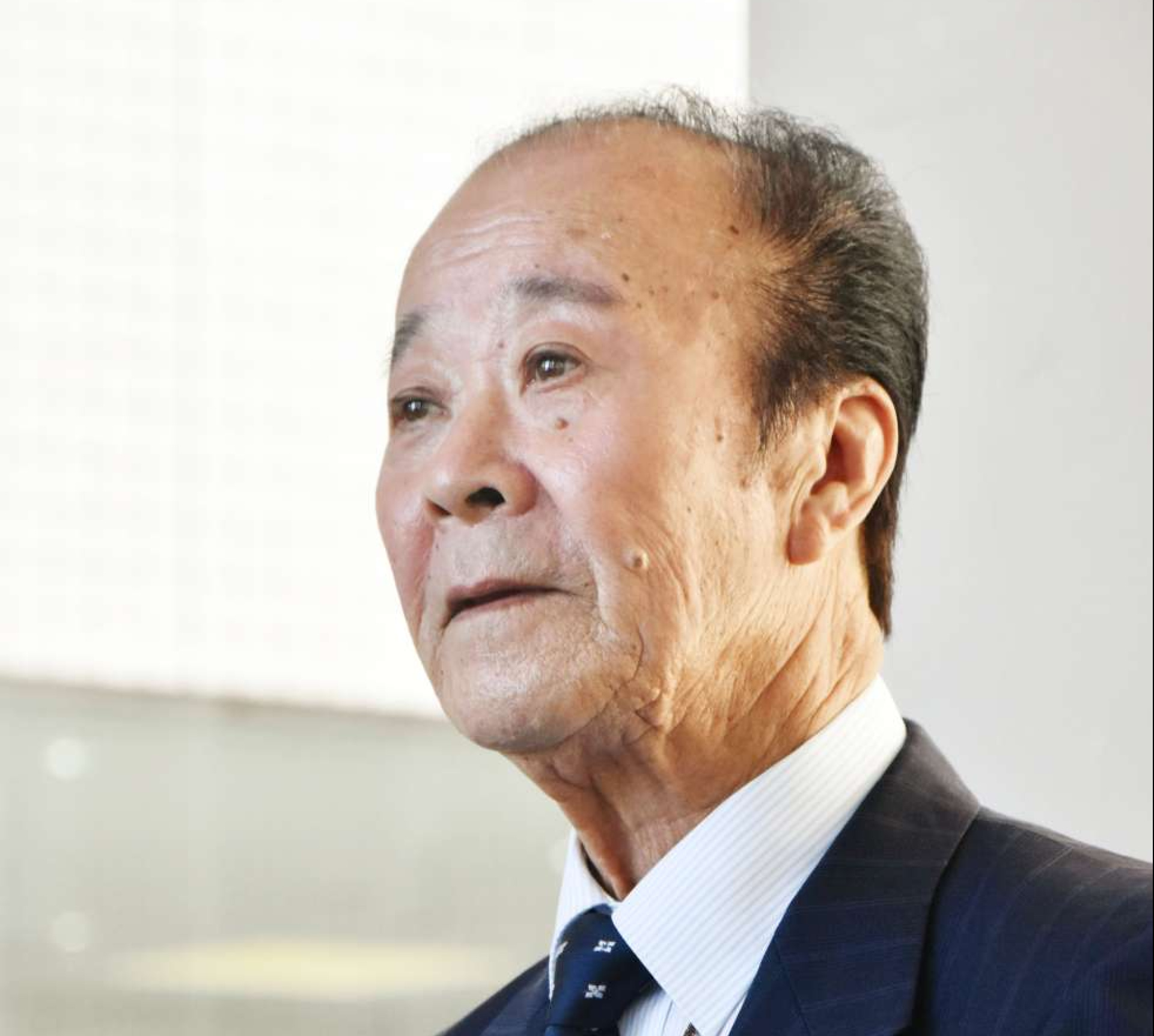 報道陣の取材に応じる市川健一さん＝２６日、姶良市の加音ホール