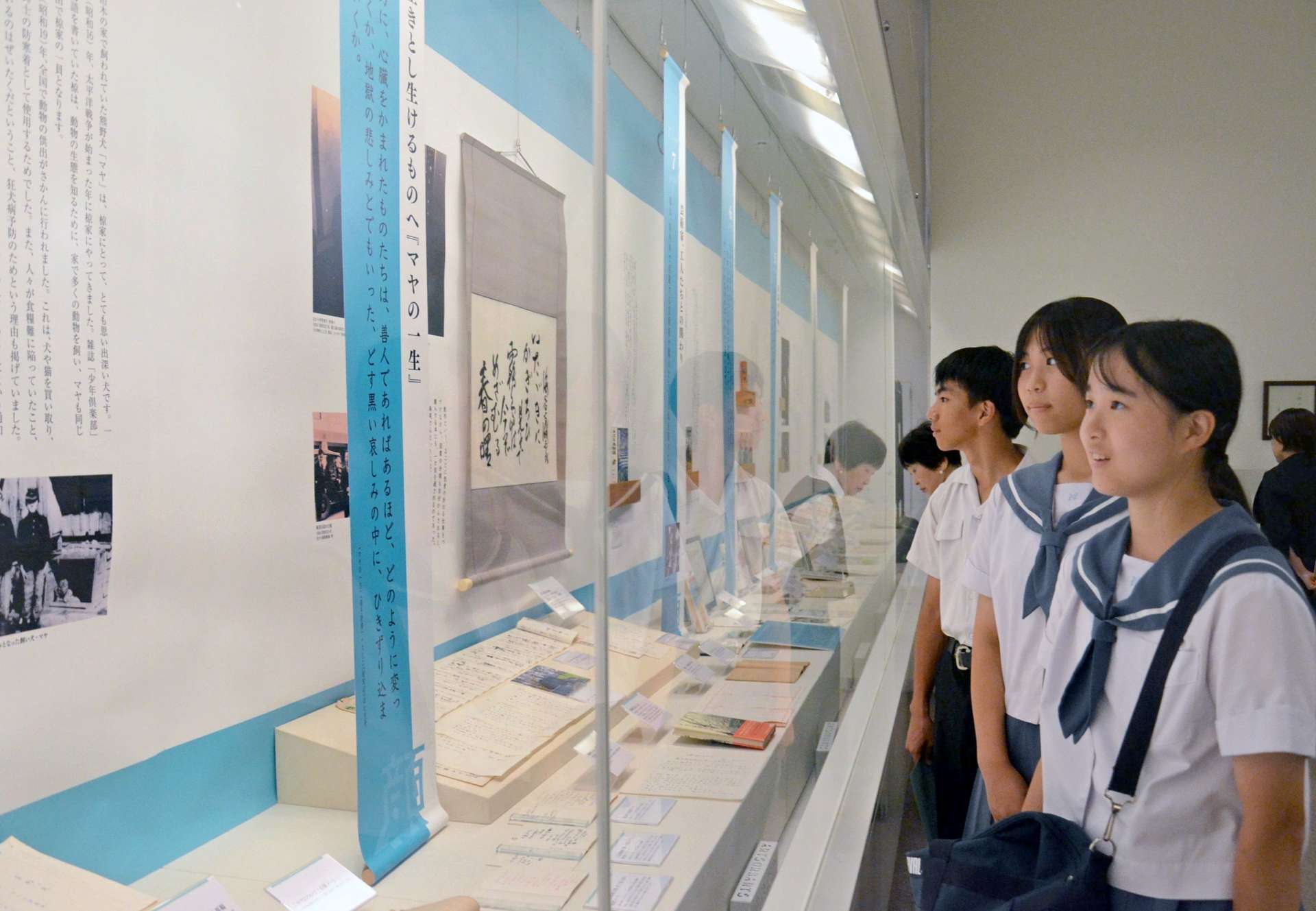 資料を眺める長田中学校の生徒ら＝２６日、鹿児島市のかごしま近代文学館