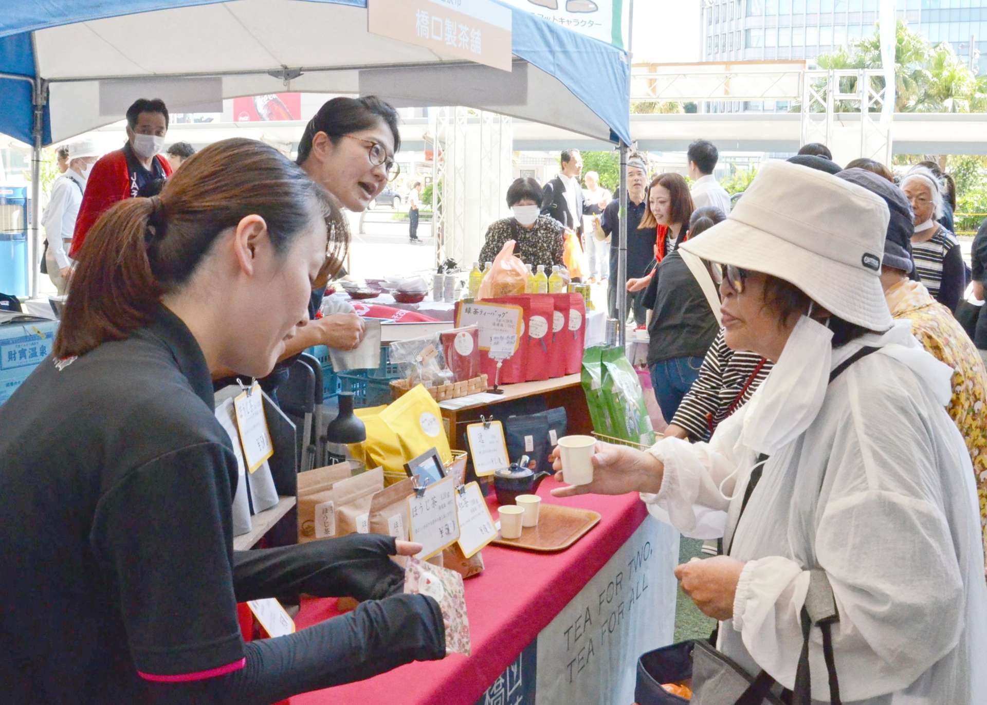 来場客に自慢の逸品を勧める出店者＝２７日、鹿児島市のＪＲ鹿児島中央駅前アミュ広場