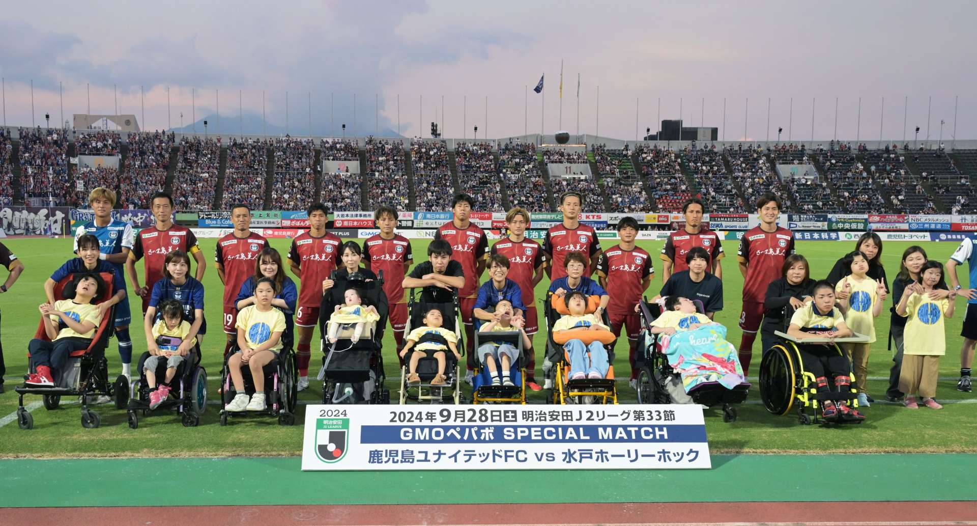 鹿児島ユナイテッドＦＣの選手と記念撮影をする子どもたち＝２８日、鹿児島市の白波スタジアム（佐伯直樹撮影）
