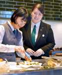 開店前準備をする後輩を見守る木下綾さん（右）＝２５日、鹿児島市の城山ホテル鹿児島