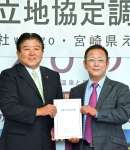 村岡隆明市長（左）と立地協定書を持つウェルゾの金尾佳文社長＝３０日、えびの市役所