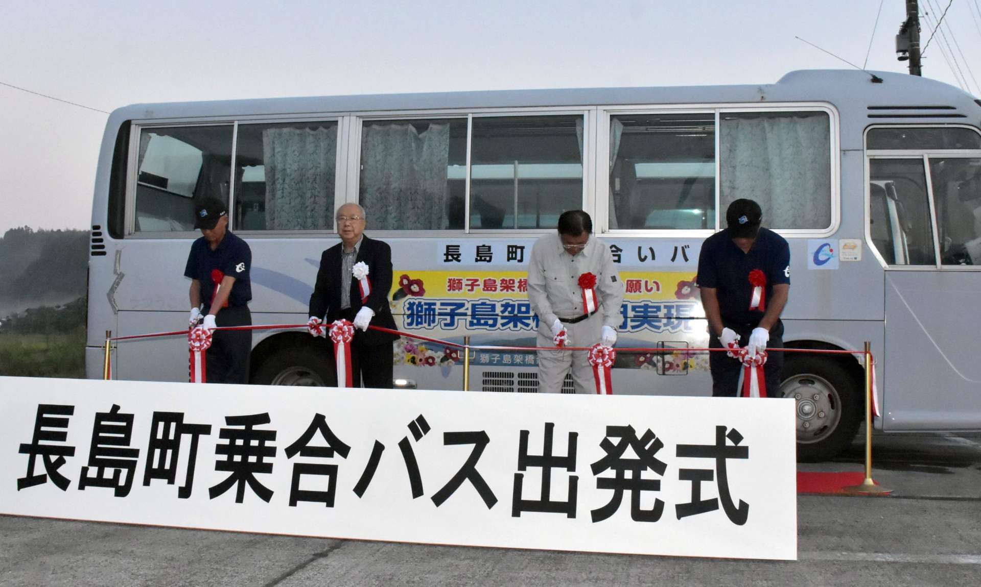 運行開始を祝い、テープカットする川添健町長（左から２人目）ら＝１日午前６時１０分、長島町平尾