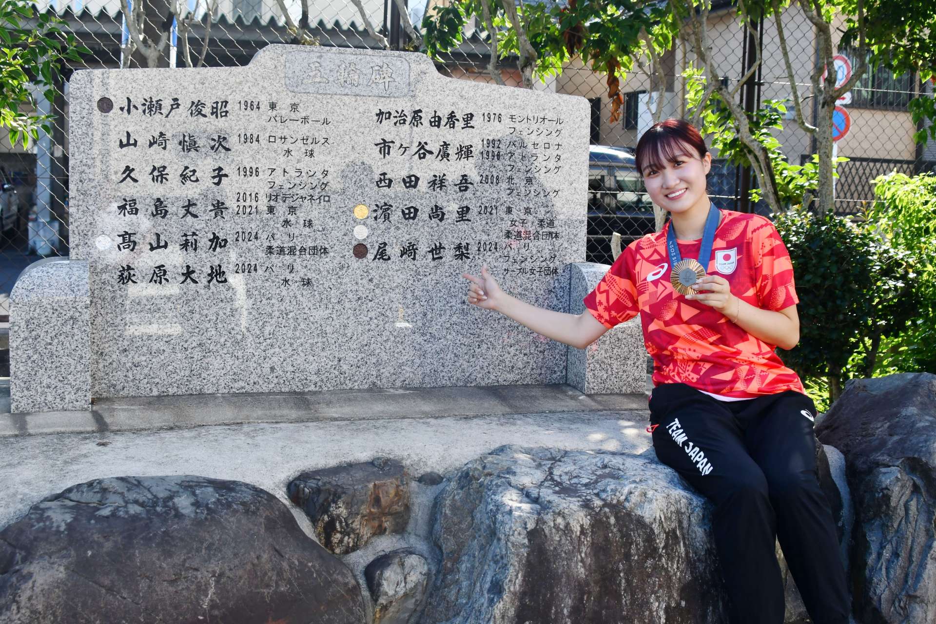 五輪碑に自身の名が刻まれ喜ぶ尾崎世梨＝鹿児島南高