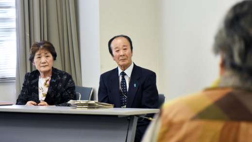〈別カット〉本紙ひろば欄を読み上げる参加者を見つめる市川夫妻＝９月２６日、姶良市の加音ホール