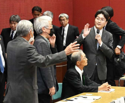 〈関連〉懇談会でマイクを切った国の対応に抗議する被害者団体関係者ら（左）＝５月１日、熊本県水俣市の水俣病情報センター