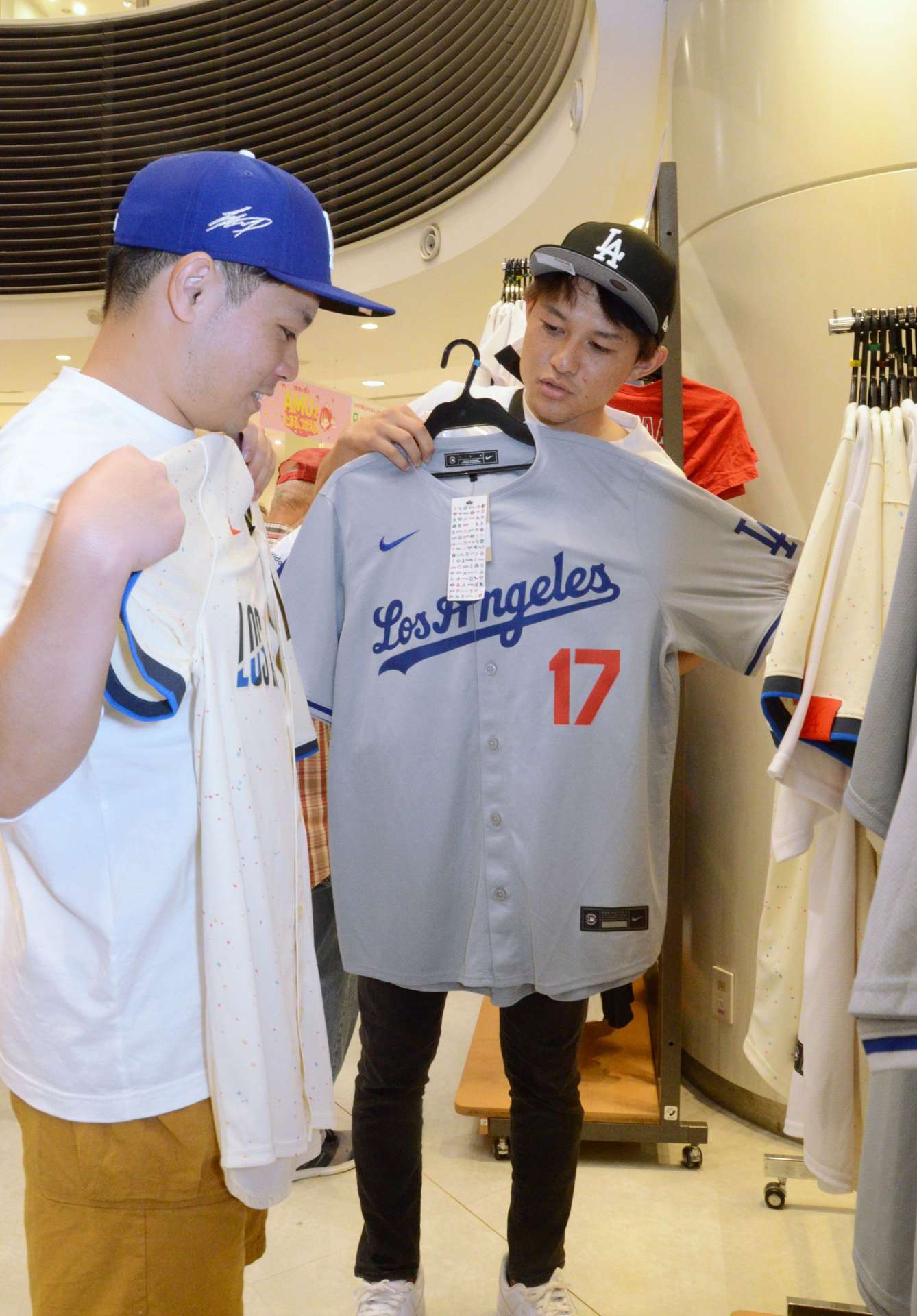 大谷翔平選手着用のものと同じデザインのユニホームを選ぶ客＝４日、鹿児島市のアミュプラザ鹿児島