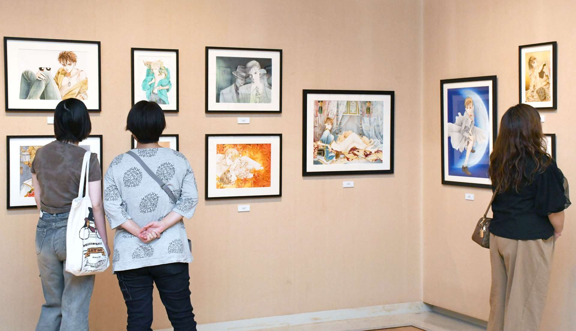 作品シリーズごとに展示された原画に見入る来場者＝鹿児島市の長島美術館