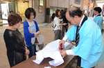 アイロン掛けの実演に見入る買い物客＝鹿児島市