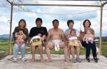 赤ちゃんの土俵入りで孫たちの健やかな成長を祈る橋口春男さん（中央）＝５日、伊佐市菱刈川北