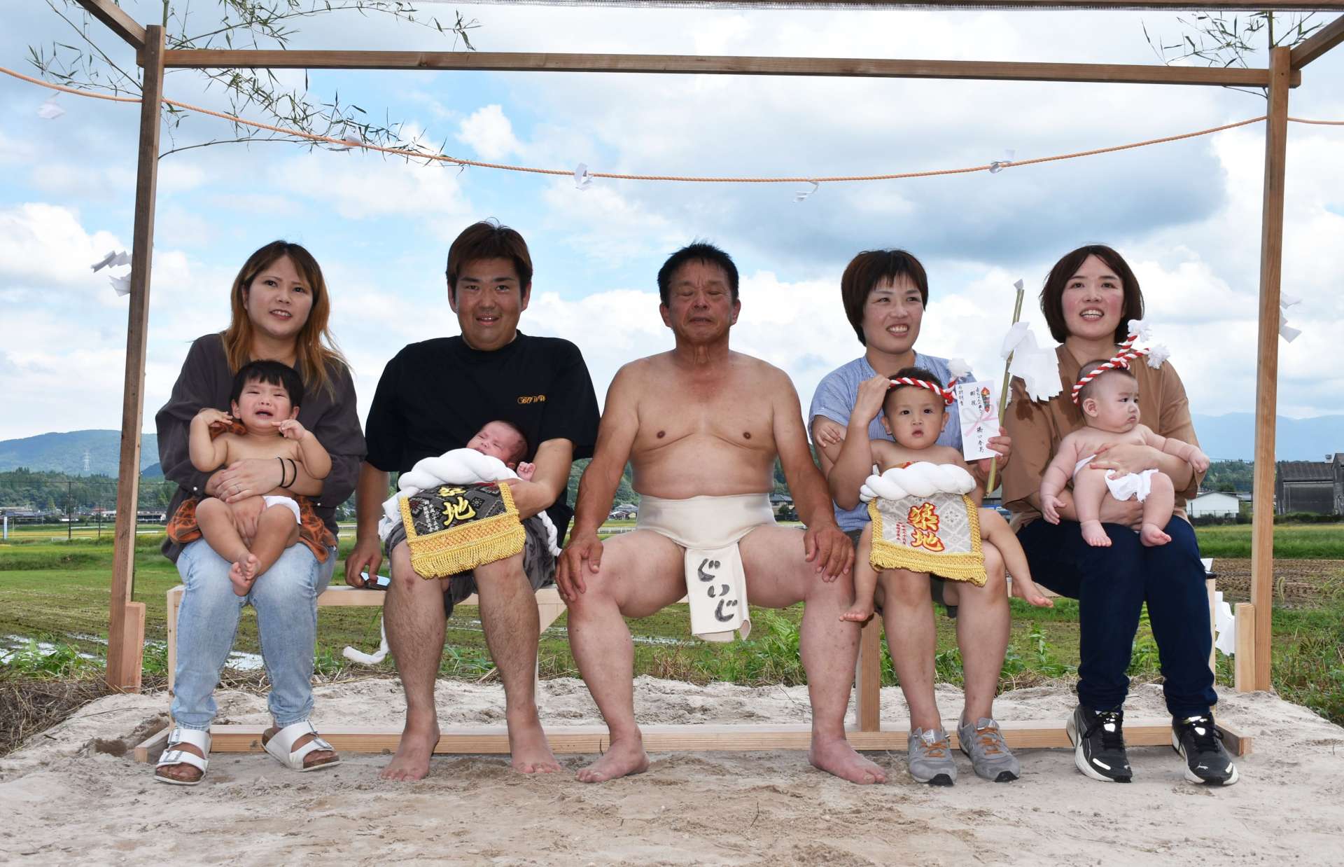 赤ちゃんの土俵入りで孫たちの健やかな成長を祈る橋口春男さん（中央）＝５日、伊佐市菱刈川北