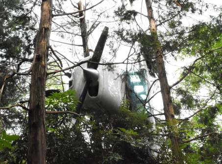 〈資料写真〉６月１０日、霧島市の山の中で木に引っかかった状態の小型機＝同市隼人町西光寺