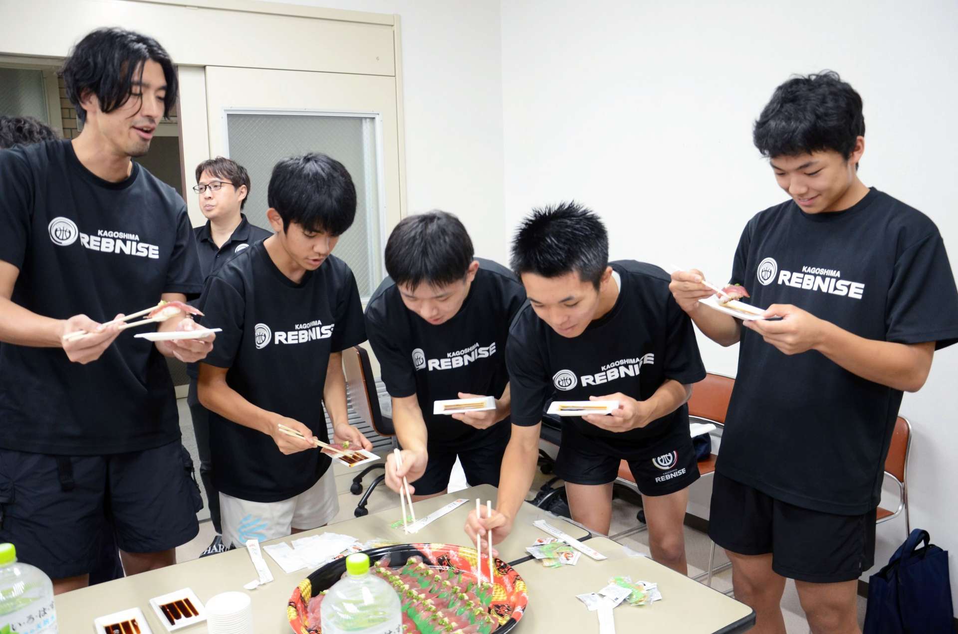 生鮮カツオのにぎりずしを味わう鹿児島レブナイズの選手＝鹿児島市のＭＢＣ城山ビル