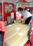 投票所整理券を車に積み込む郵便局の担当者＝１１日、鹿児島市役所
