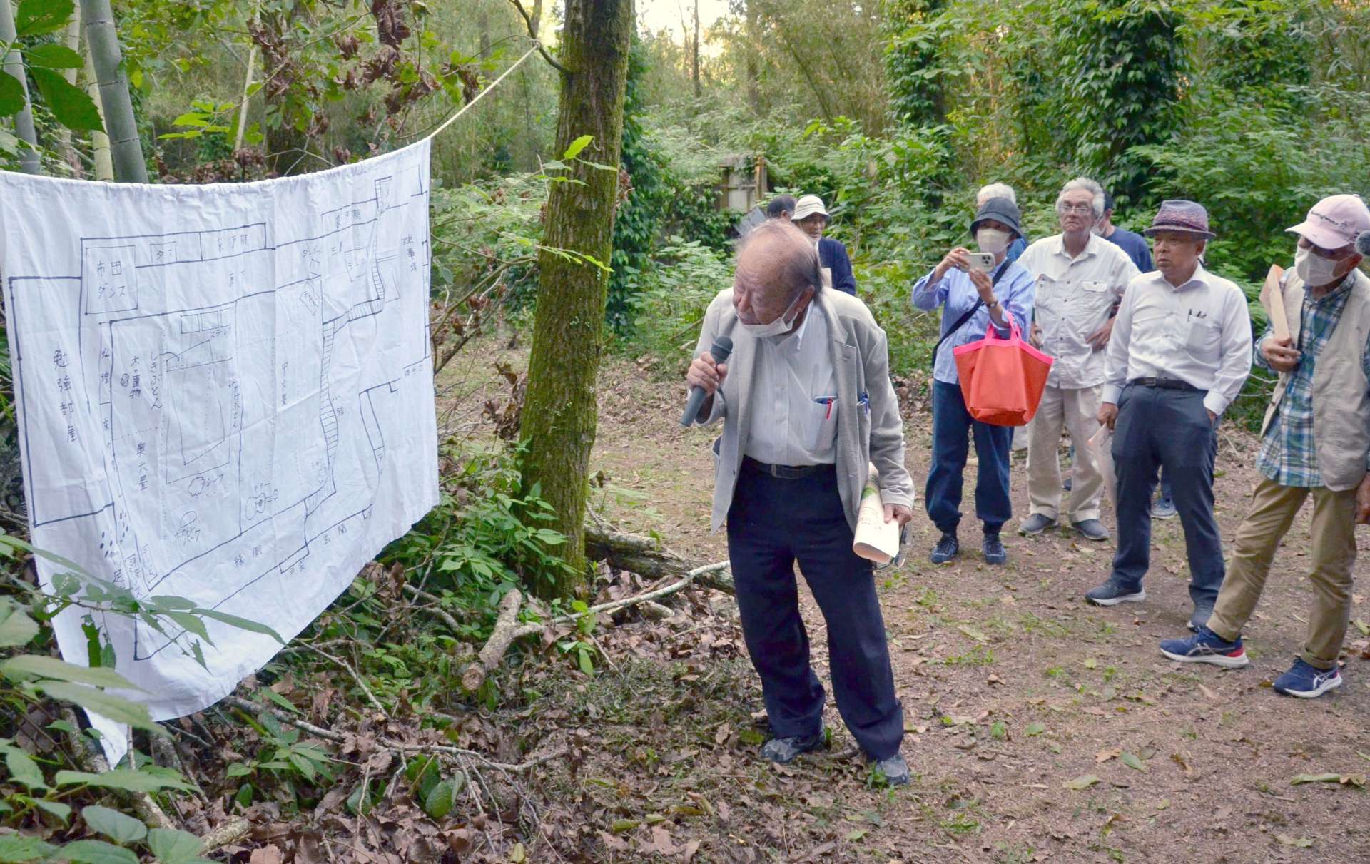 遺体が見つかった男性宅の跡地で、現場の見取り図を元に当時の状況を説明する永仮正弘弁護士＝１２日午後、大崎町