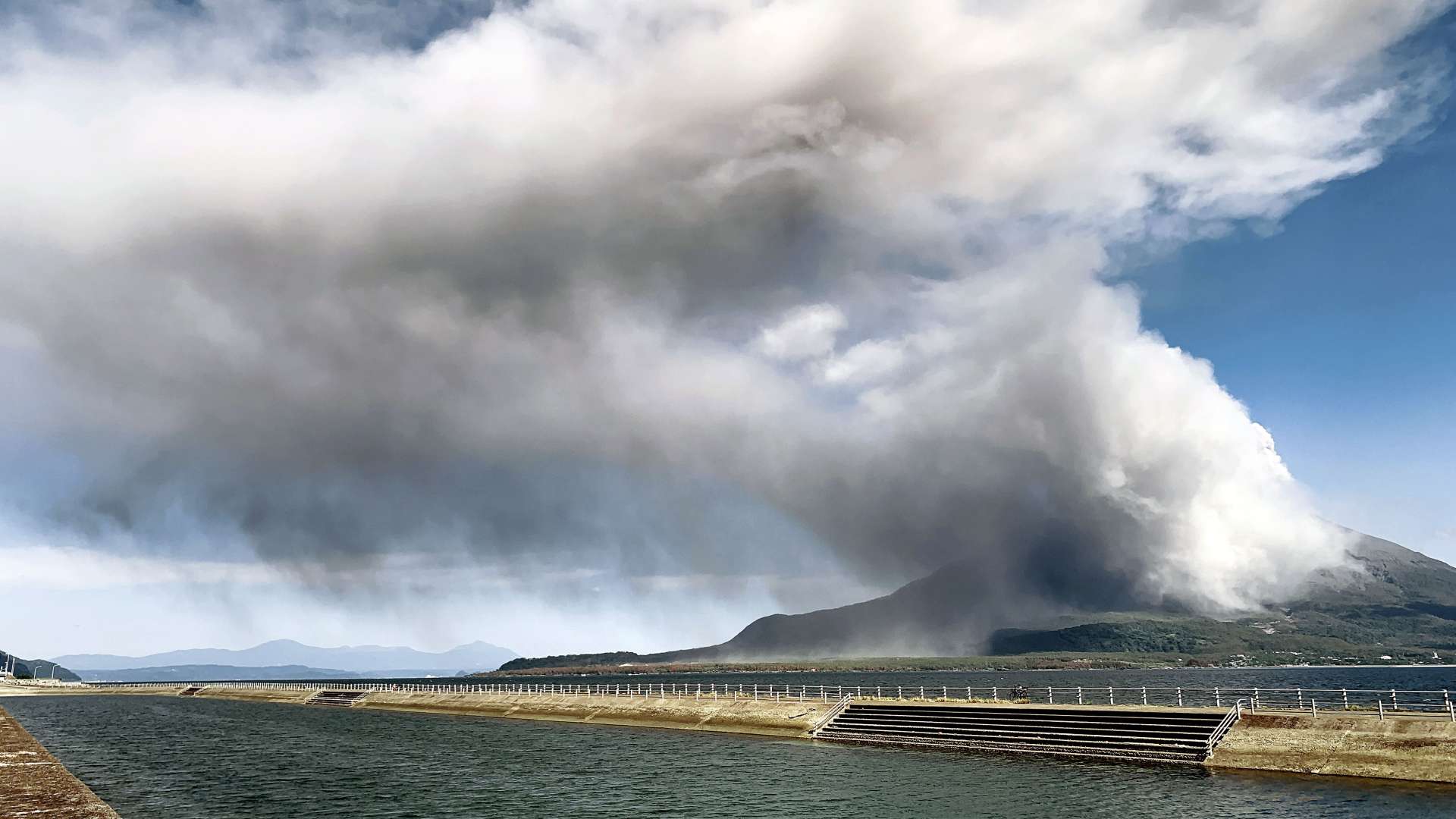 鹿児島湾を渡り鹿児島市街地方面に流れる桜島の灰＝１３日午後１時すぎ、鹿児島市与次郎１丁目