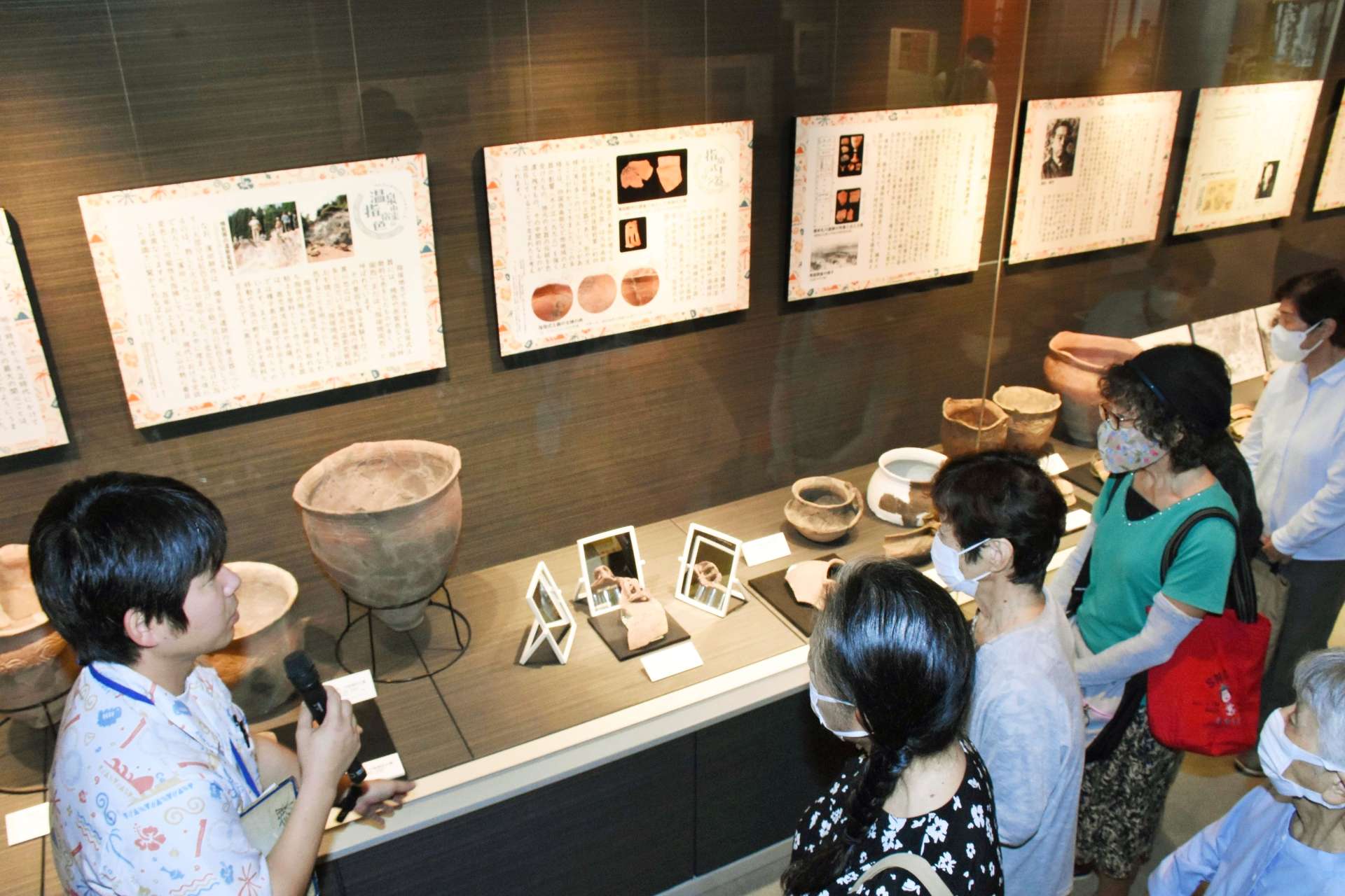 橋牟礼川遺跡の歴史を紹介する展示に見入る人々＝指宿市の時遊館ＣＯＣＣＯはしむれ