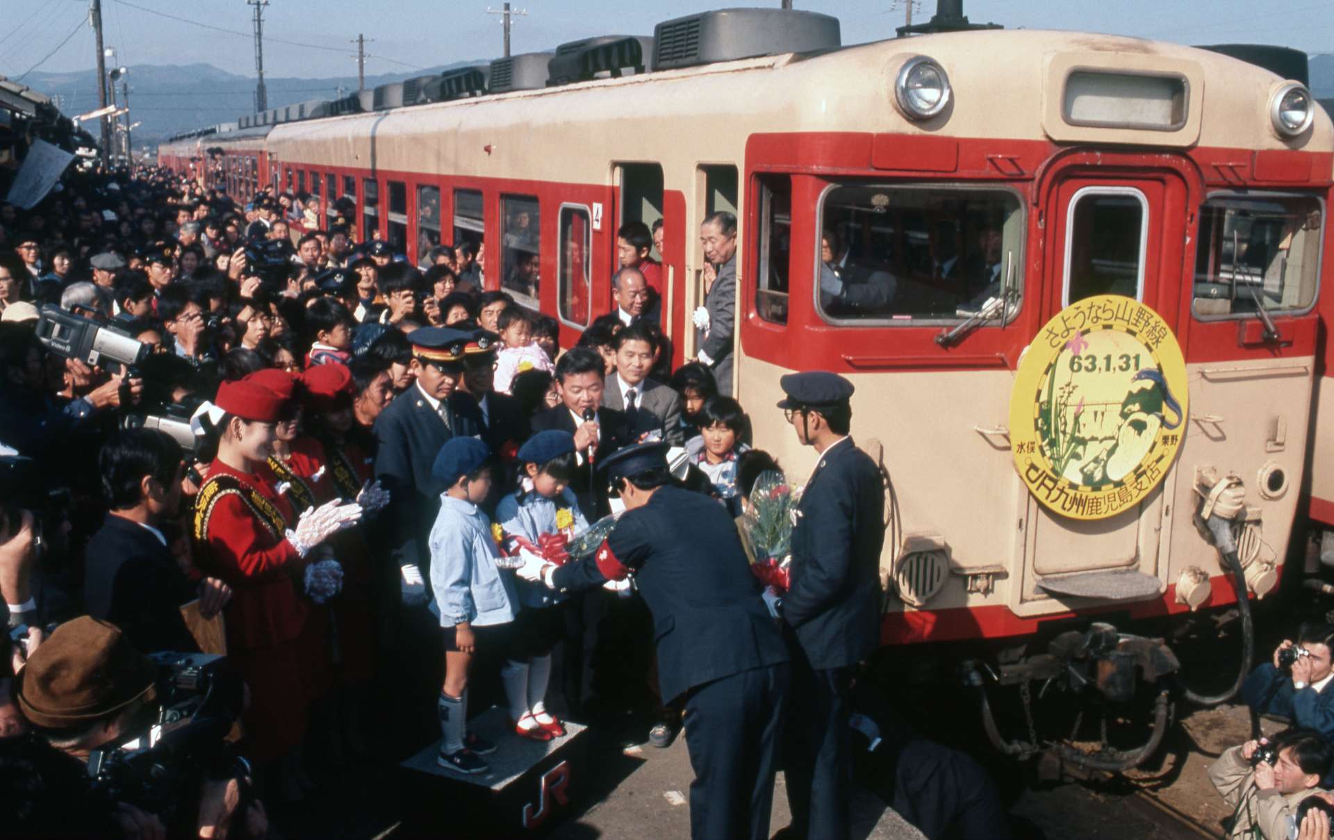 １９８８年１月３１日、鹿児島県内の廃止対象ローカル線最後のＪＲ山野線が廃止の日の発車風景。園児が花束を贈って乗務員をねぎらった＝ＪＲ薩摩大口駅