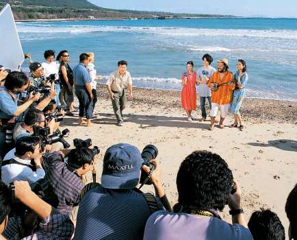 ２００７年１２月、映画「虹をつかむ男」の撮影で徳之島を訪れ、海で写真撮影する西田敏行さんら＝徳之島町