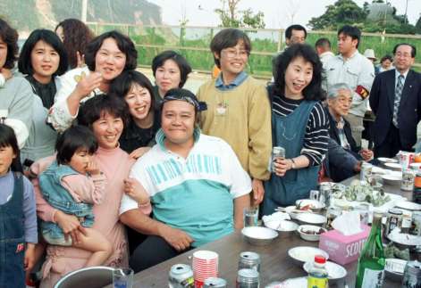 〈関連〉１９９７年４月、映画「釣りバカ日誌」の撮影で訪れた下甑での交流会で地域住民に囲まれて、にこやかな西田敏行さん（手前中央）＝薩摩川内市甑島