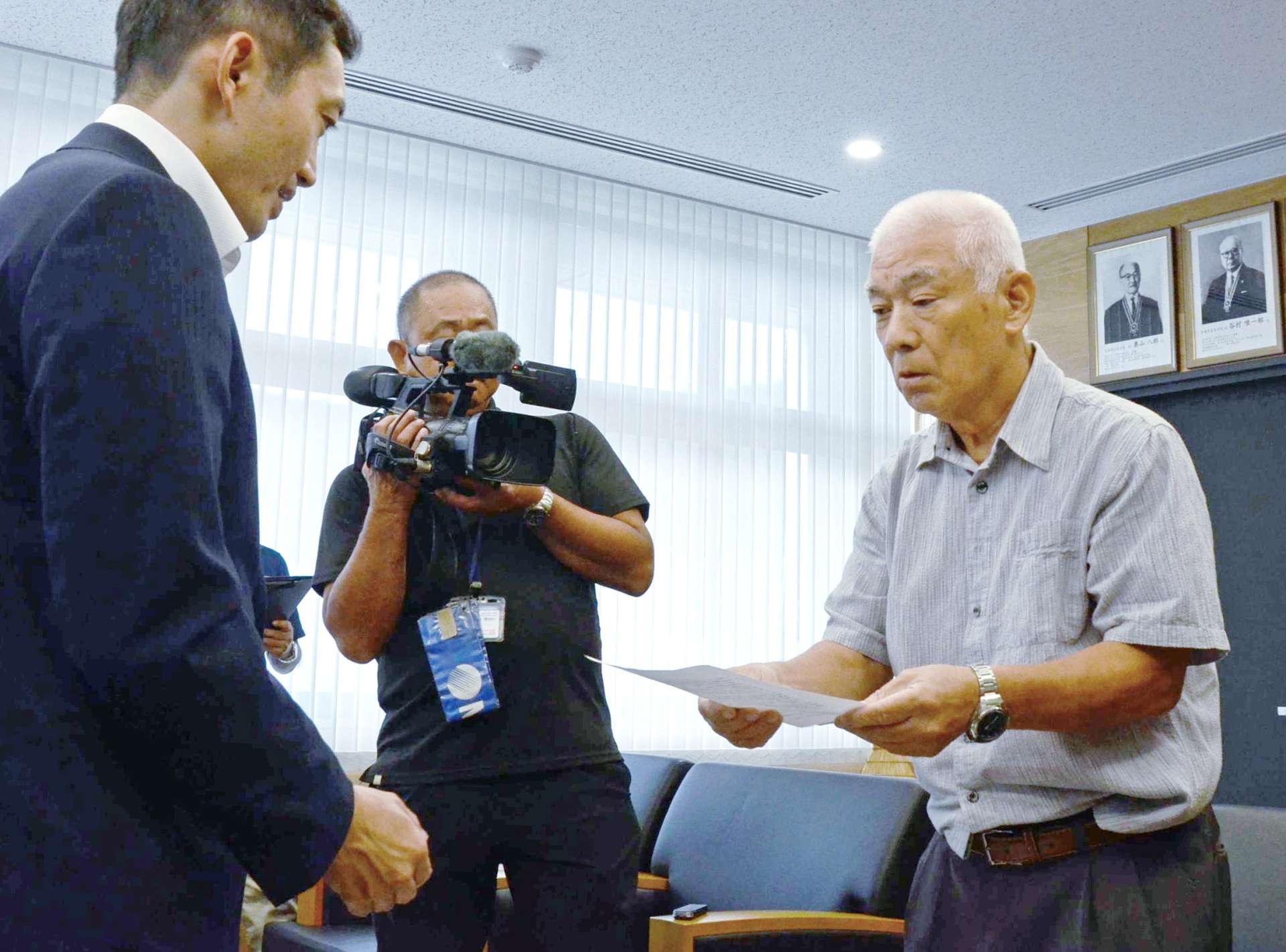 要請文を手渡す戸玉集落の浦口一弘区長（右）＝１７日、奄美市役所