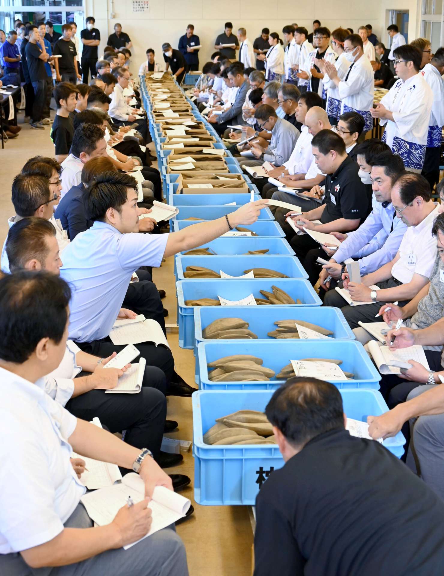 威勢のいい掛け声とともに進むかつお節の産地入札会＝１８日、枕崎市立神本町