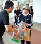 試読紙を受け取る買い物客＝１９日、鹿児島市与次郎１丁目