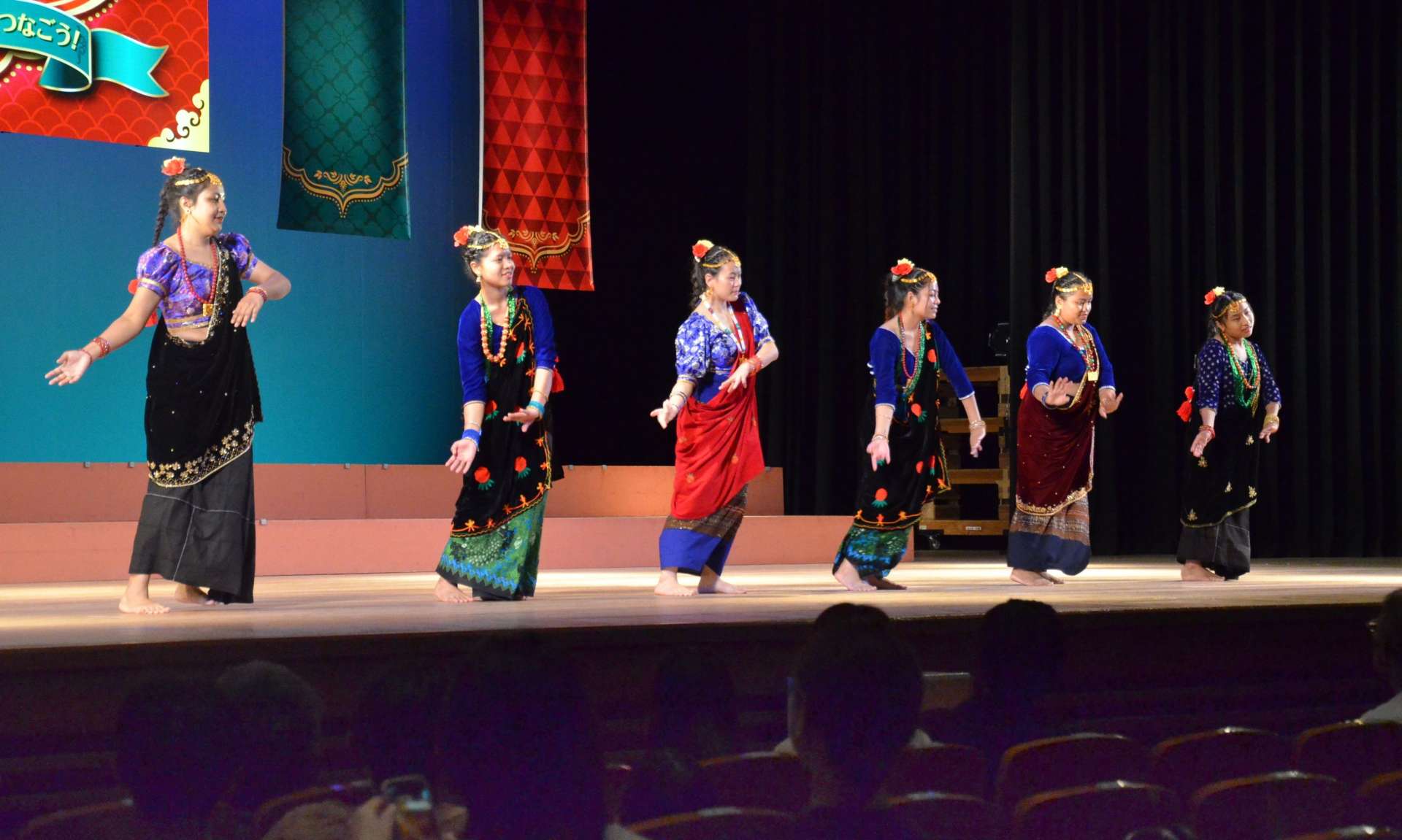 民族衣装を着て伝統舞踊を披露するネパール人留学生たち＝１９日、鹿児島市の宝山ホール