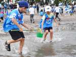 海水をくむ参加者＝２０日、姶良市の重富海岸