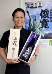 「俊寛」コラボ焼酎をＰＲする平裕介主幹＝鹿児島市の三島村役場