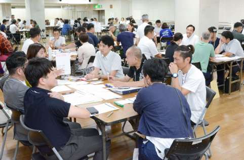 桜島をテーマとする外国人富裕層向けのツアー内容を考える観光関係者ら＝８月２１日、鹿児島市の宝山ホール