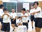 細い竹筒で作った突き鉄砲で的を狙う児童たち＝西之表市の伊関小学校