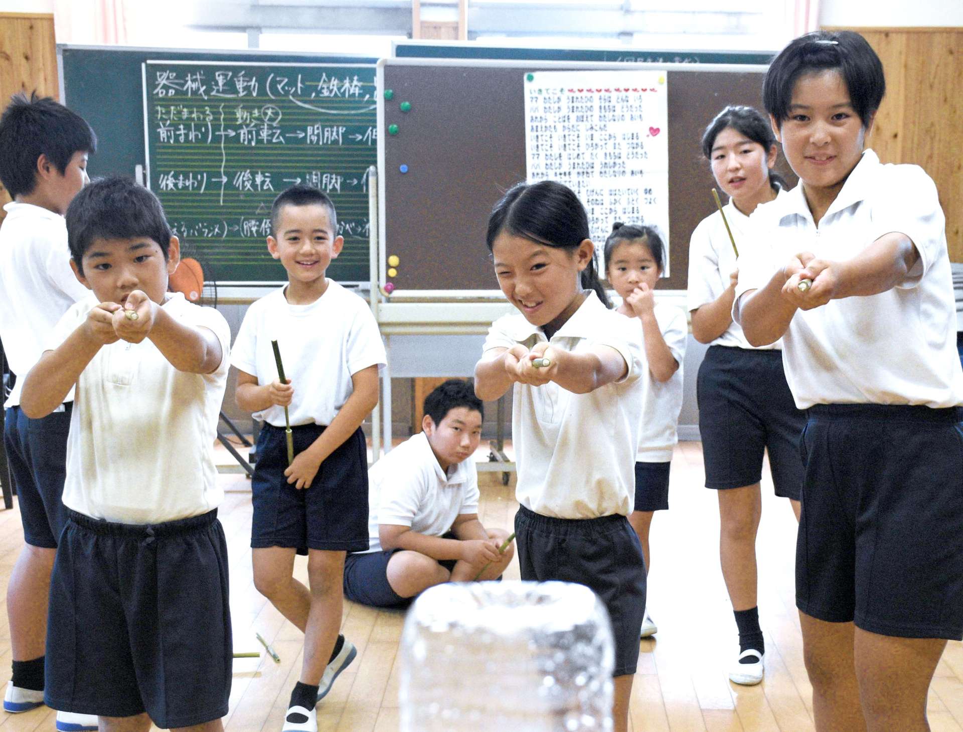 細い竹筒で作った突き鉄砲で的を狙う児童たち＝西之表市の伊関小学校