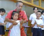 細い竹筒で作った突き鉄砲を試す児童ら＝西之表市の伊関小学校