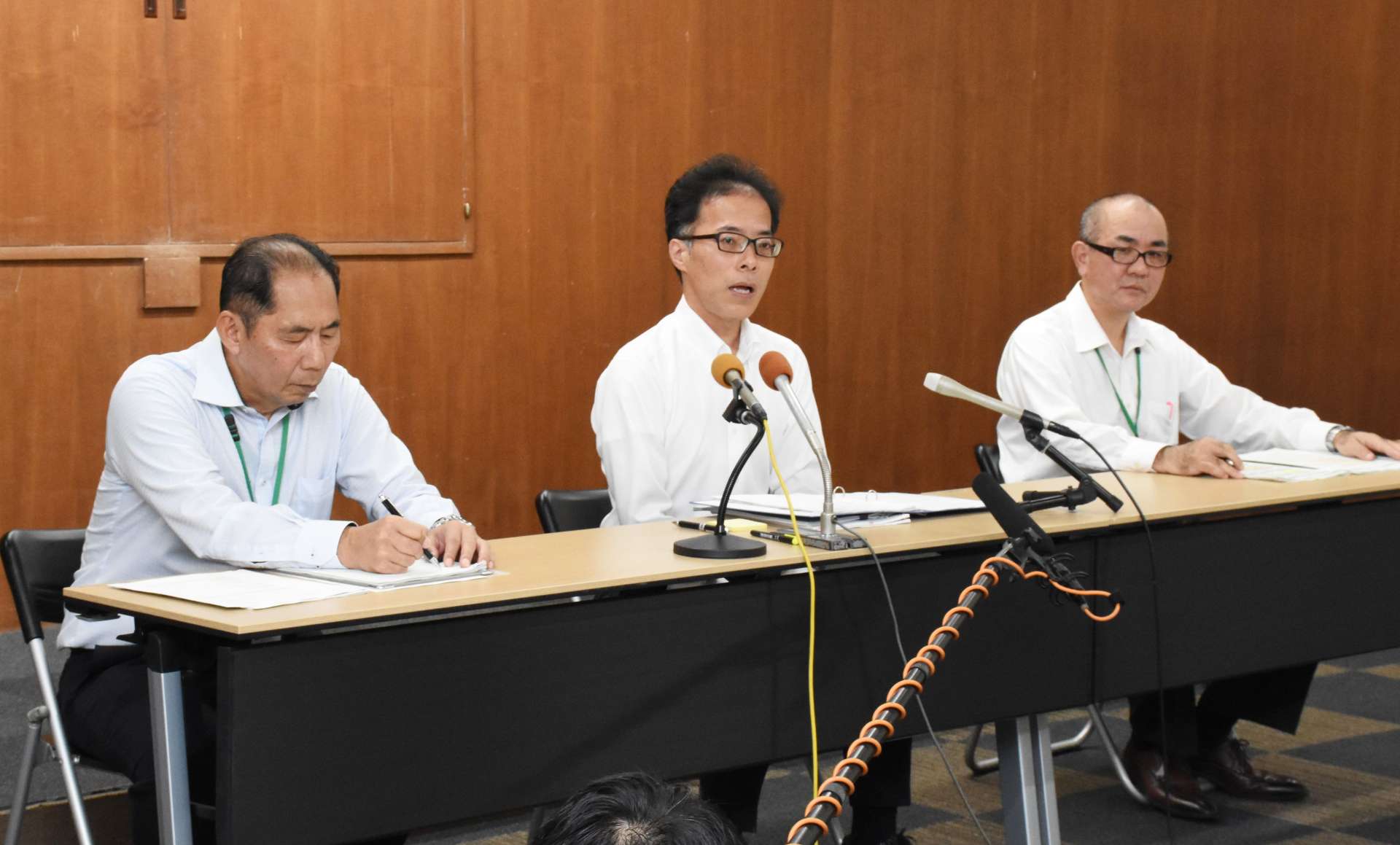 会見で行政処分を発表する指宿市の黒永英樹副市長（中央）＝２２日、指宿市役所