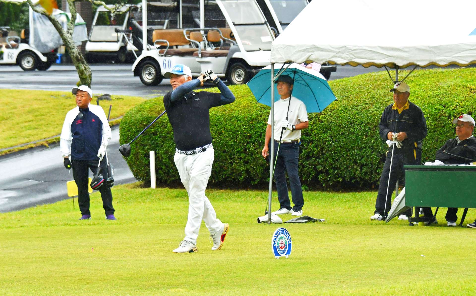 雨の中、ティーショットを打つ選手＝２２日、霧島市の溝辺ＣＣ