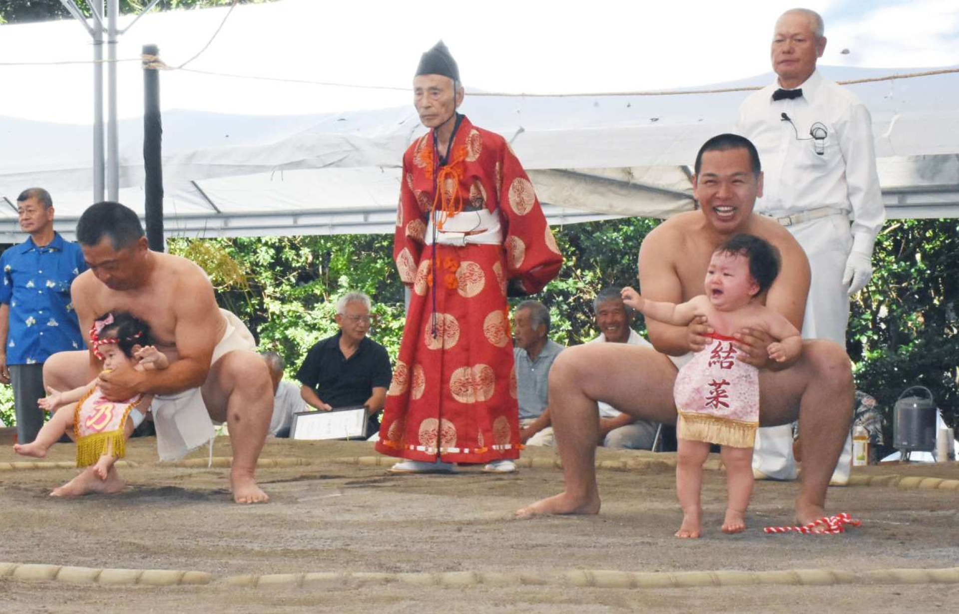 力士に抱えられ、土俵入りする赤ちゃん＝指宿市の枚聞神社