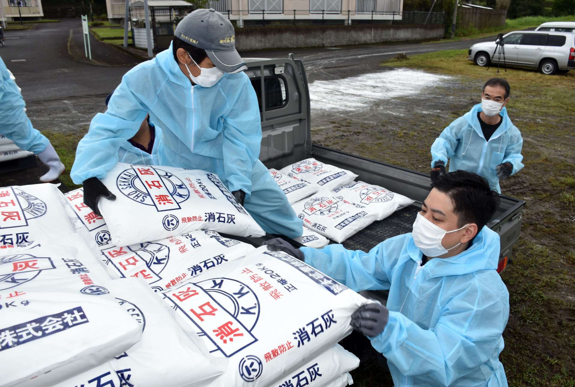 消石灰を軽トラックに積み込む市職員ら＝２５日、薩摩川内市入来町副田