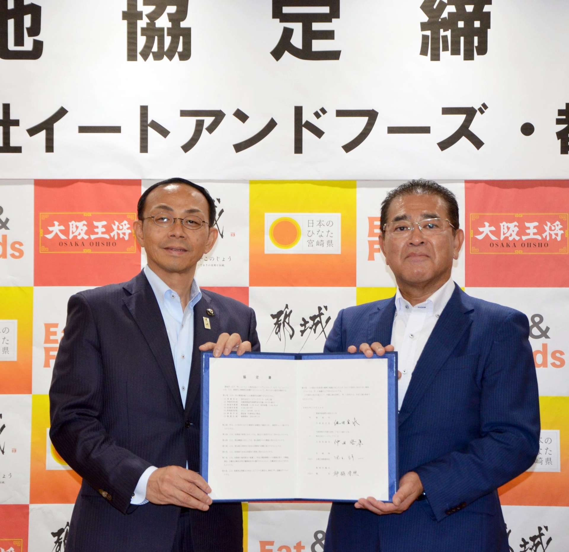 協定書を交わす池田宜永都城市長（左）とイートアンドフーズの仲田浩康社長＝２５日、都城市役所