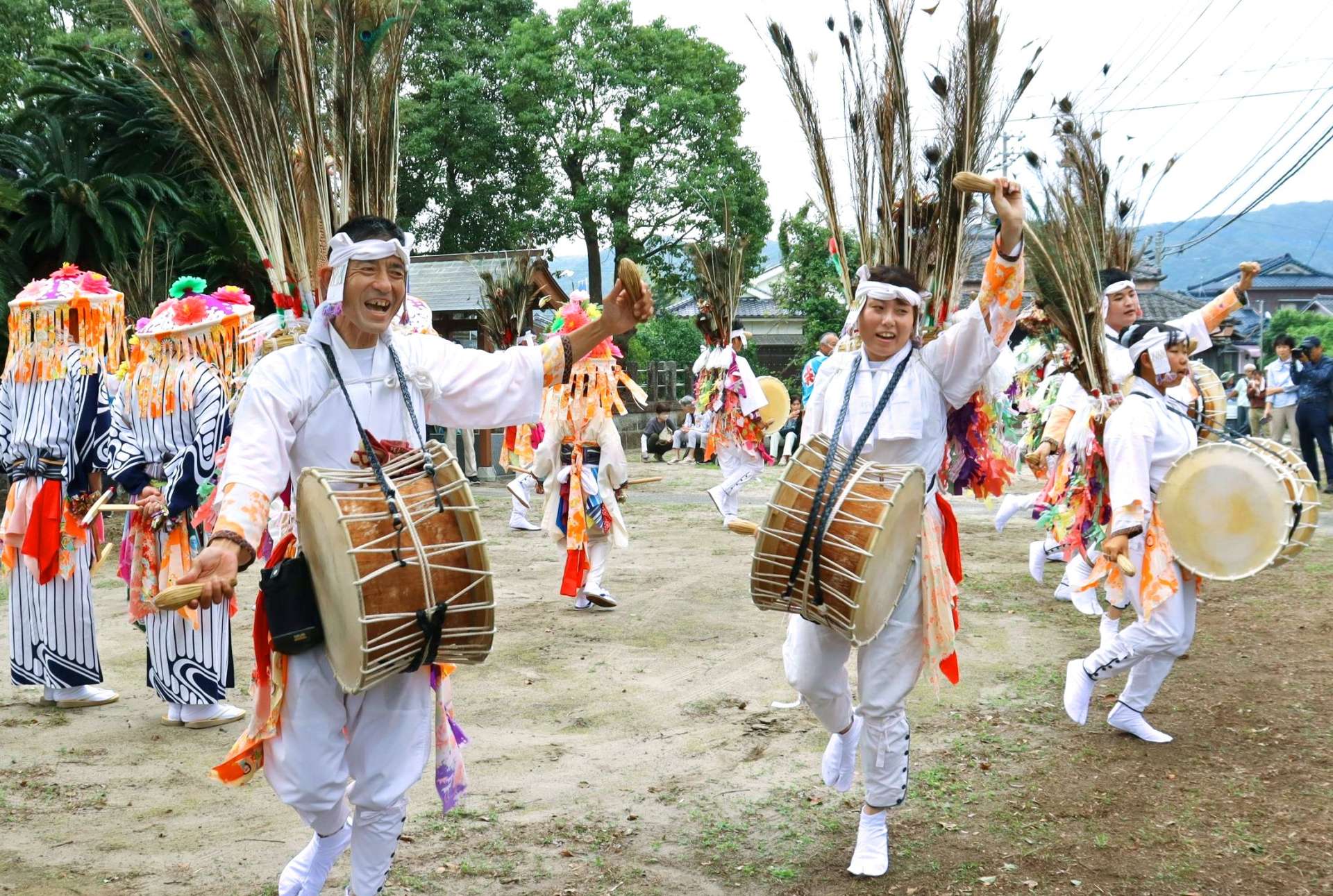 鮮やかな飾りを背負って踊る参加者＝南さつま市加世田小湊