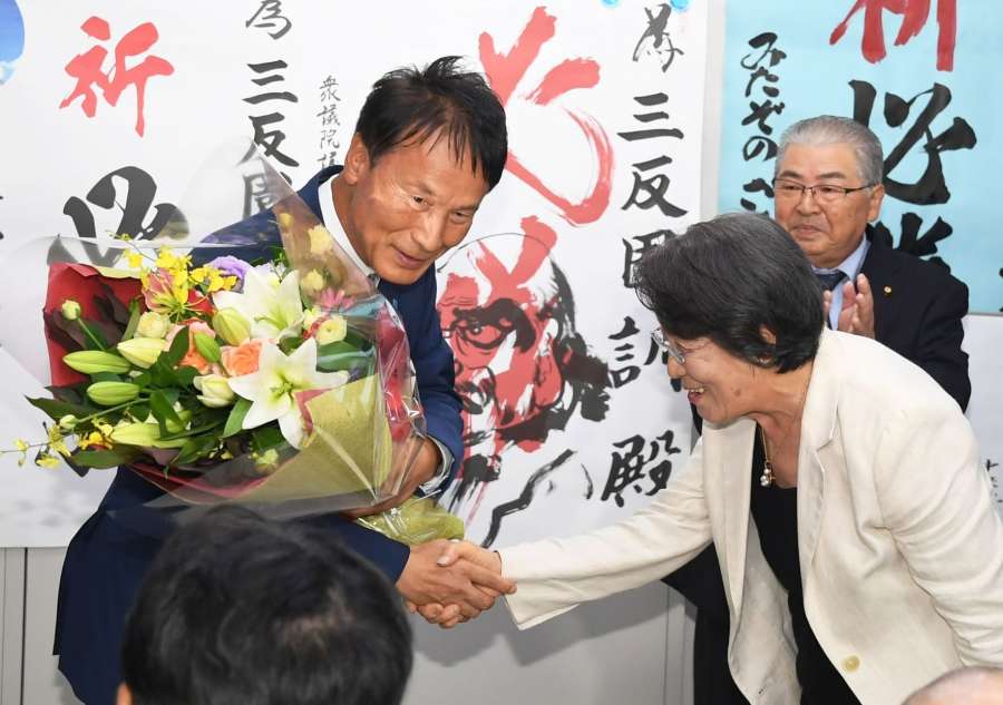 支持者から花束を受け取る三反園訓さん＝２７日午後８時９分、鹿児島市谷山中央３丁目