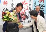 支持者から花束を受け取る三反園訓さん＝２７日午後８時９分、鹿児島市谷山中央３丁目