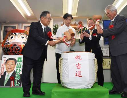 鏡開きをする森山裕さんの陣営関係者＝２７日午後８時２０分、鹿屋市大浦町