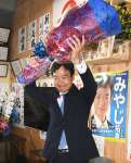 比例九州で復活当選が確実となり、花束を手に喜ぶ宮路拓馬さん＝２８日午前０時５５分、鹿児島住吉町