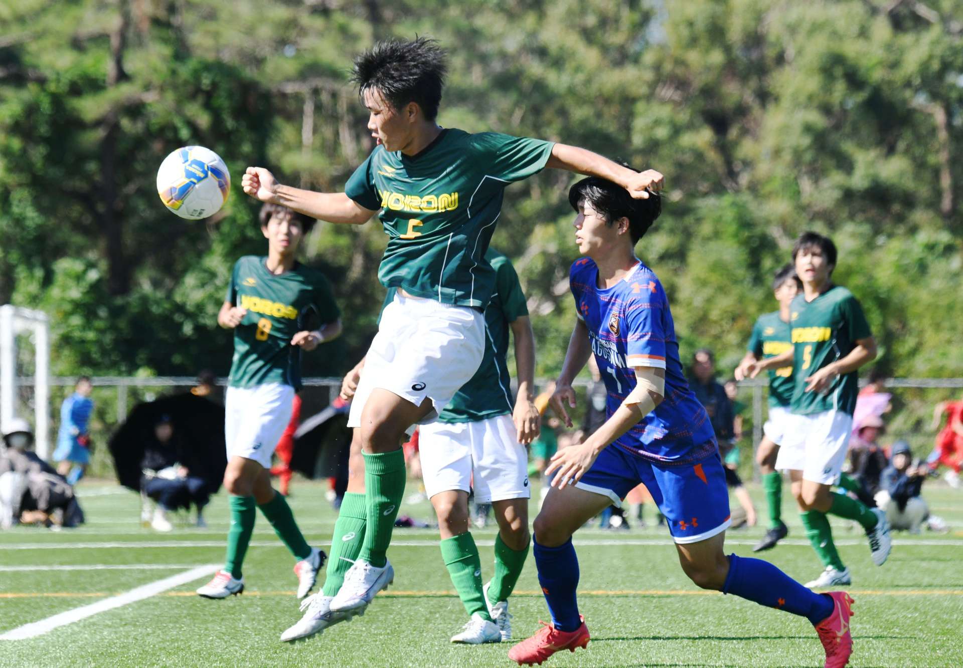 体を張った守備を見せる与論のＭＦ森園（６）＝コトブキサッカーフィールド吹上