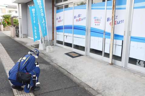 現場を調べる警察官＝２８日、鹿児島市谷山中央３丁目